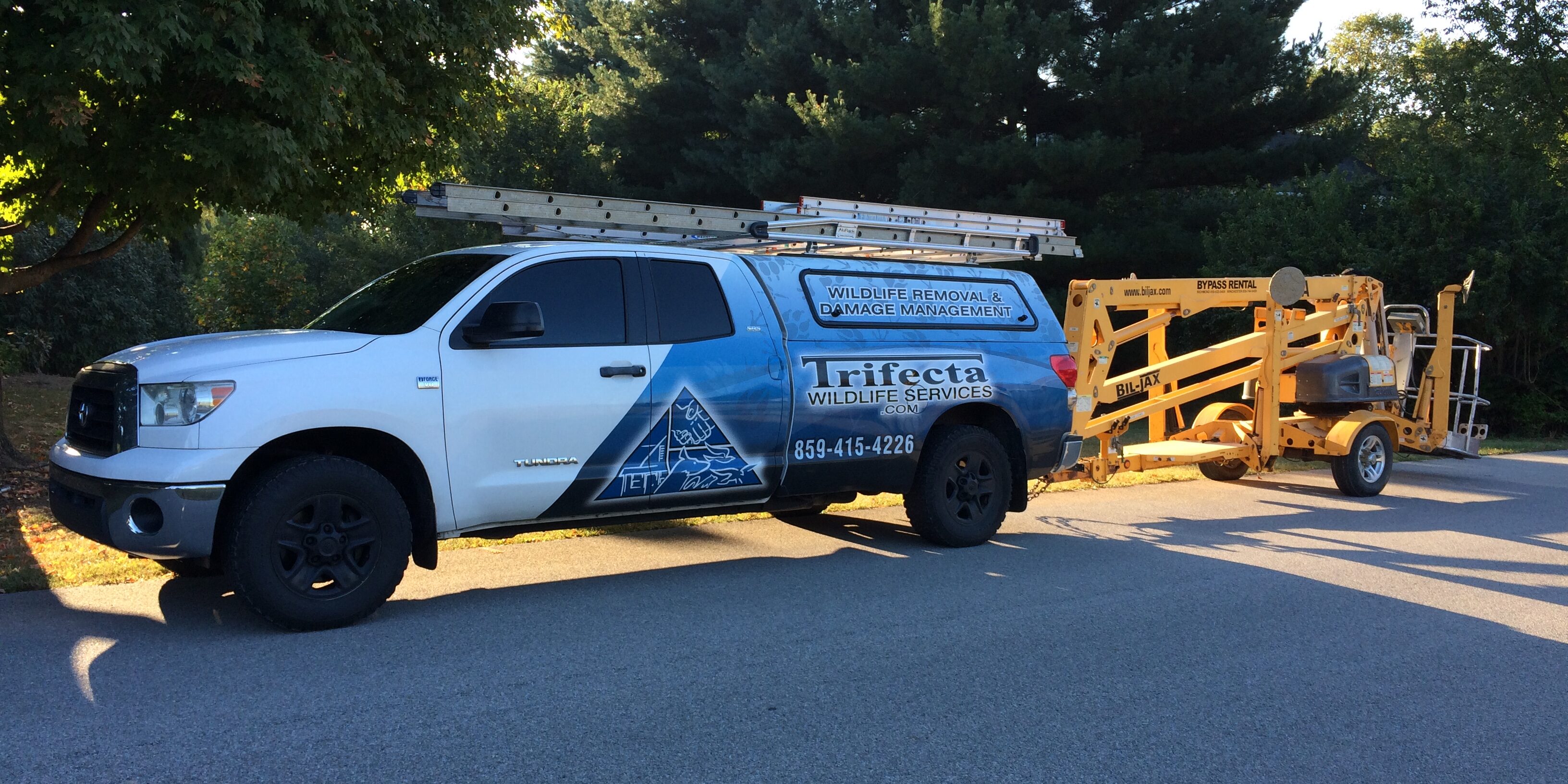 Trifecta Wildlife Services Truck With Aerial Lift The Trifecta Wildlife Services truck towing an aerial lift