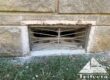 Bedford stone home foundation vent during vent guard installation process