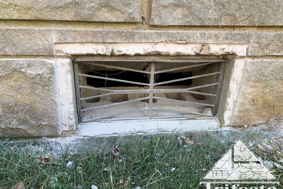 Bedford stone home foundation vent during vent guard installation process