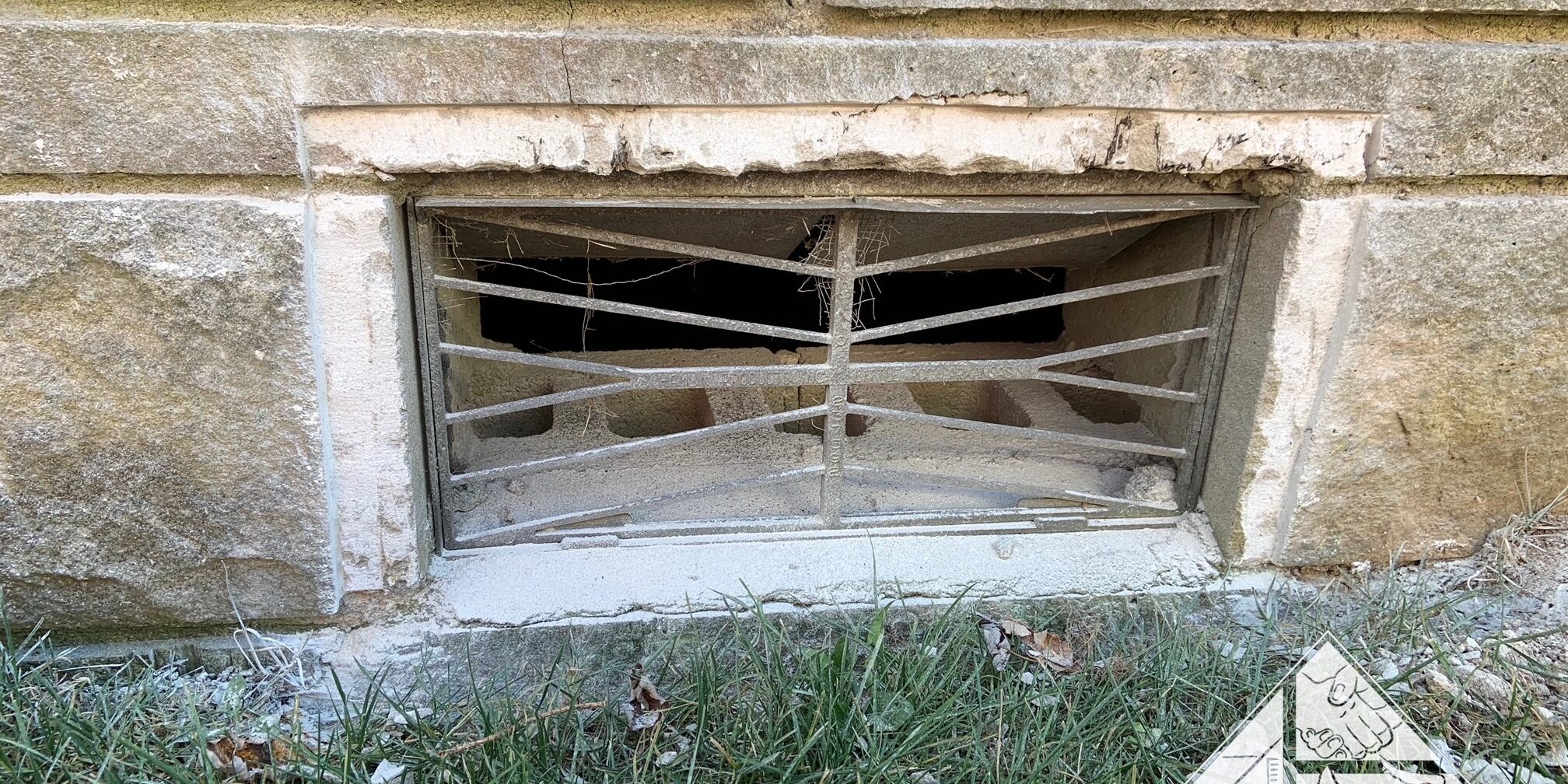 Foundation Vent on a Bedford Stone House With Stone Chiseled Out In Preparation For FVG Install Bedford stone home foundation vent during vent guard installation process