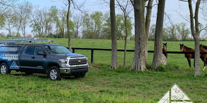 Trifecta Wildlife on a Lexington KY horse farm Trifecta Wildlife Services truck parked along some horses on a Lexington KY farm.